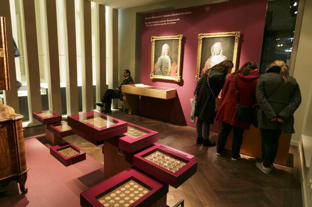 Besucher betrachten Münzen aus der Sammlung Glock/Barckhaus