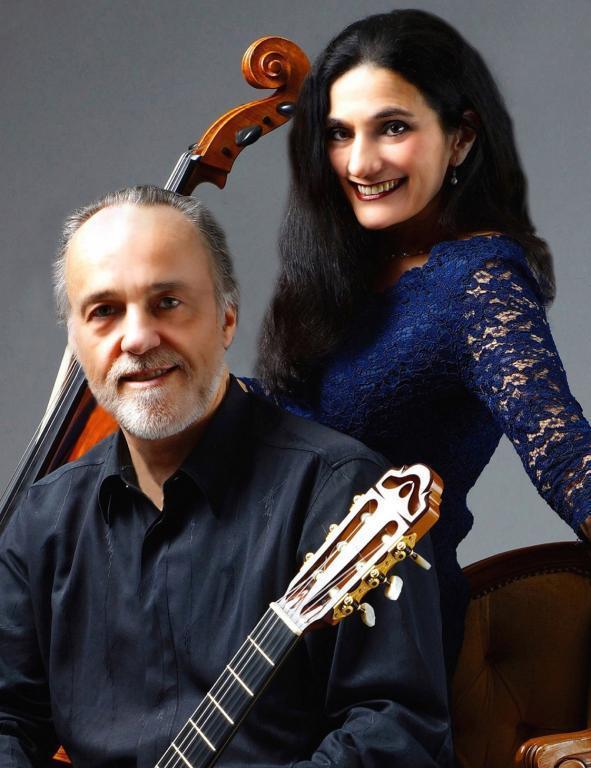 Ariana Burstein und Robert Legnani mit Cello und Gitarre vor grauem Hintergrund 