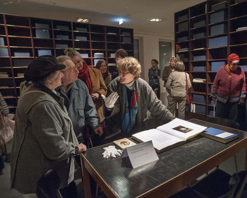 Ein Foto zeigt Besucher, die sich angeregt in der Bibliothek der Alten unterhalten