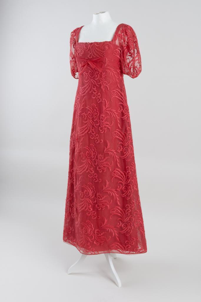 Das Foto zeigt ein rotes Kleid im Empirestil, mit Tüll aus Gallener Spitze in Rankenform.