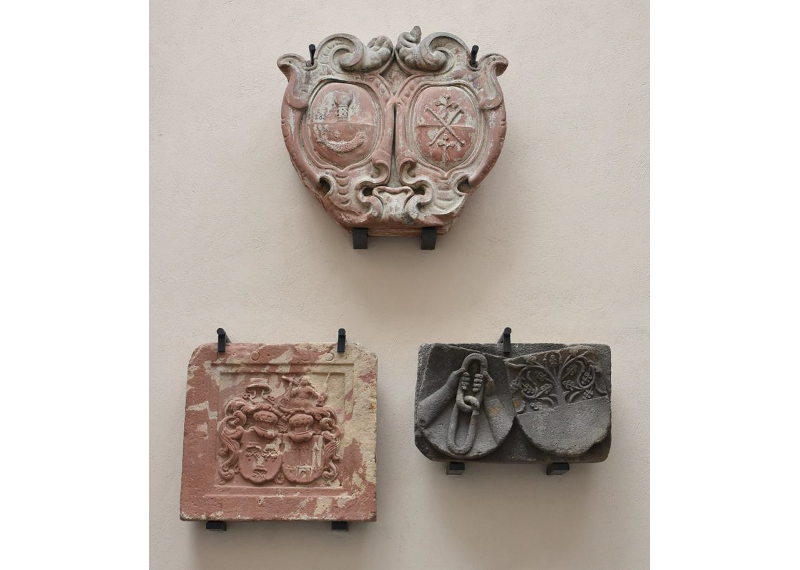 Das Foto zeigt drei verschiedene Wappensteine. 